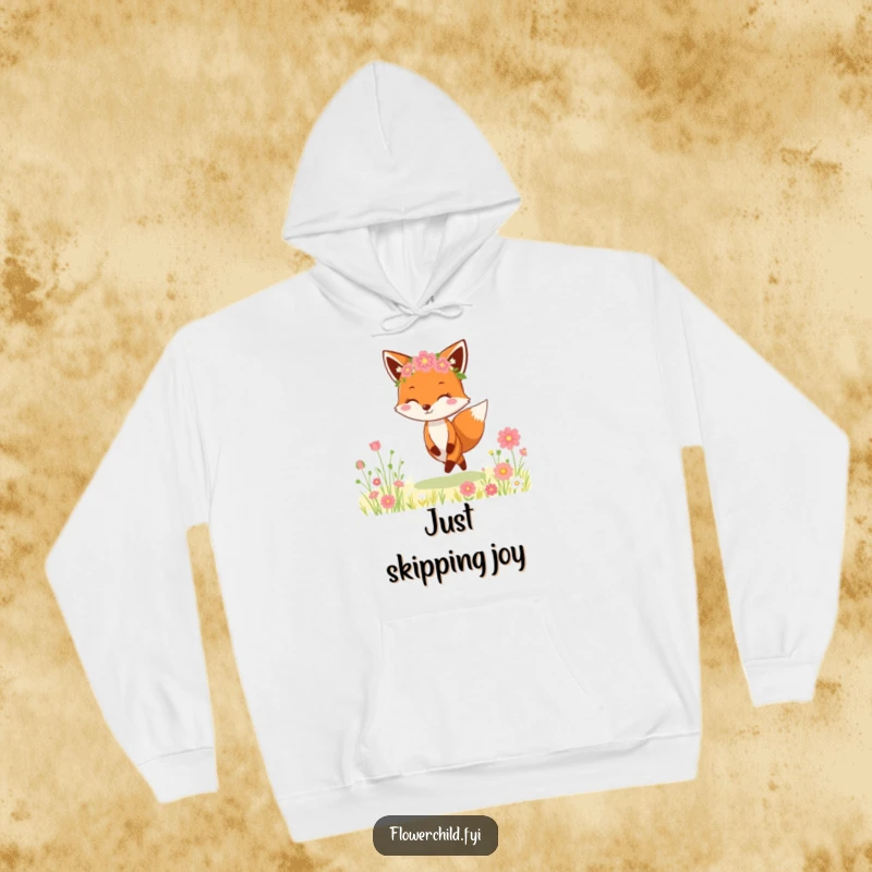 Funny Fox Flower Crown Hoodie: A cheerful fox wearing a delicate flower crown is captured mid-skip in a vibrant meadow, spreading joy.