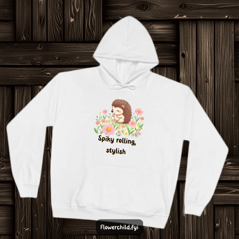 Funny hoodie depicting a happy hedgehog character in mid-roll through a meadow bursting with beautiful flowers, a heartwarming scene.