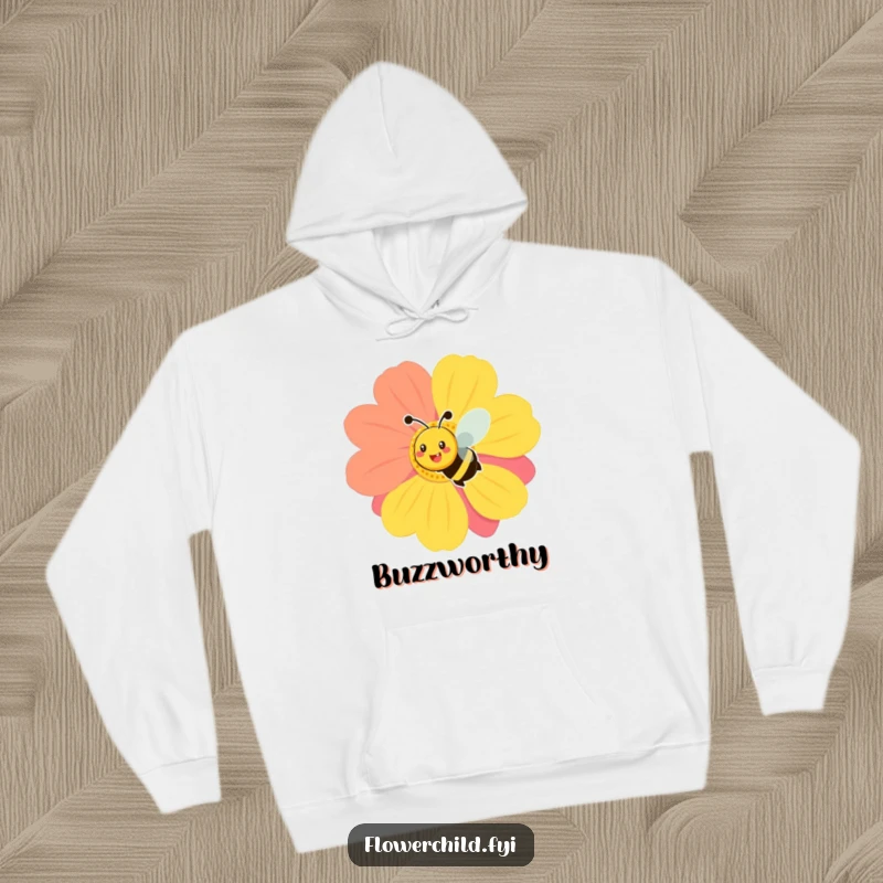 Funny cozy hoodie depicting a smiling bee in mid-buzz around a large, brightly colored flower, radiating garden cheer.